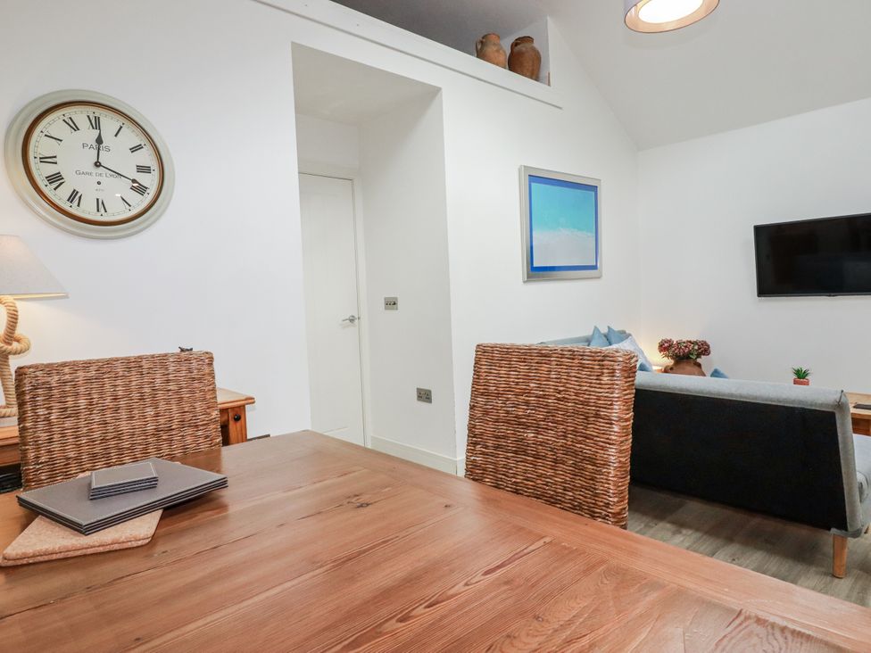 A living room with a wooden table and chairs at Cove Retreat in Penzance