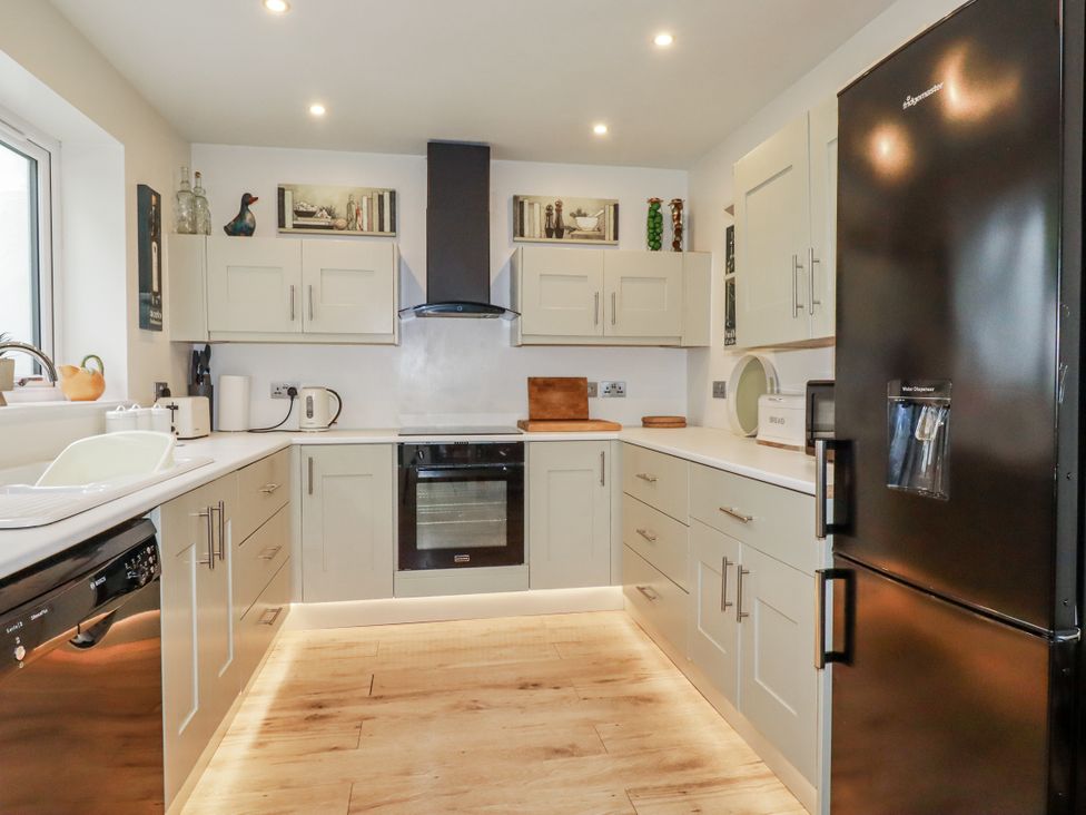 A kitchen with cabinets and appliances at Cove Retreat in Penzance