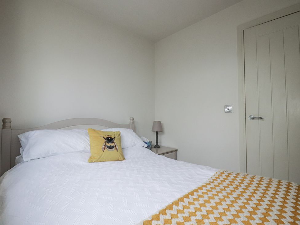 A bedroom with a bed and lamp at Cove Retreat in Penzance