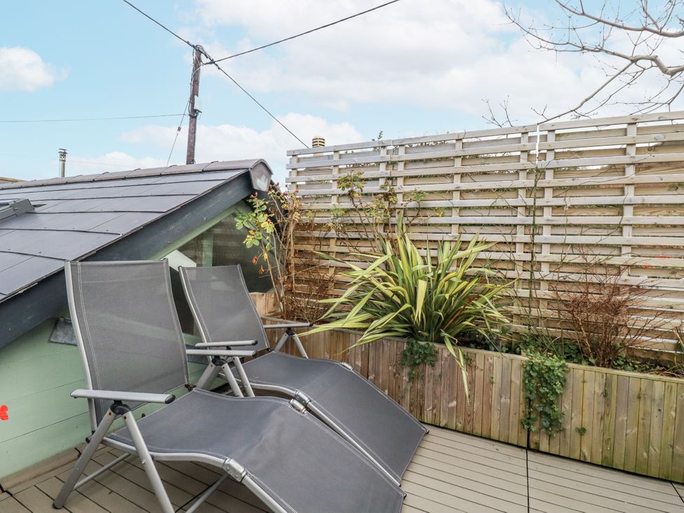 An outdoor space with deck chairs and plants at Cove Retreat in Penzance