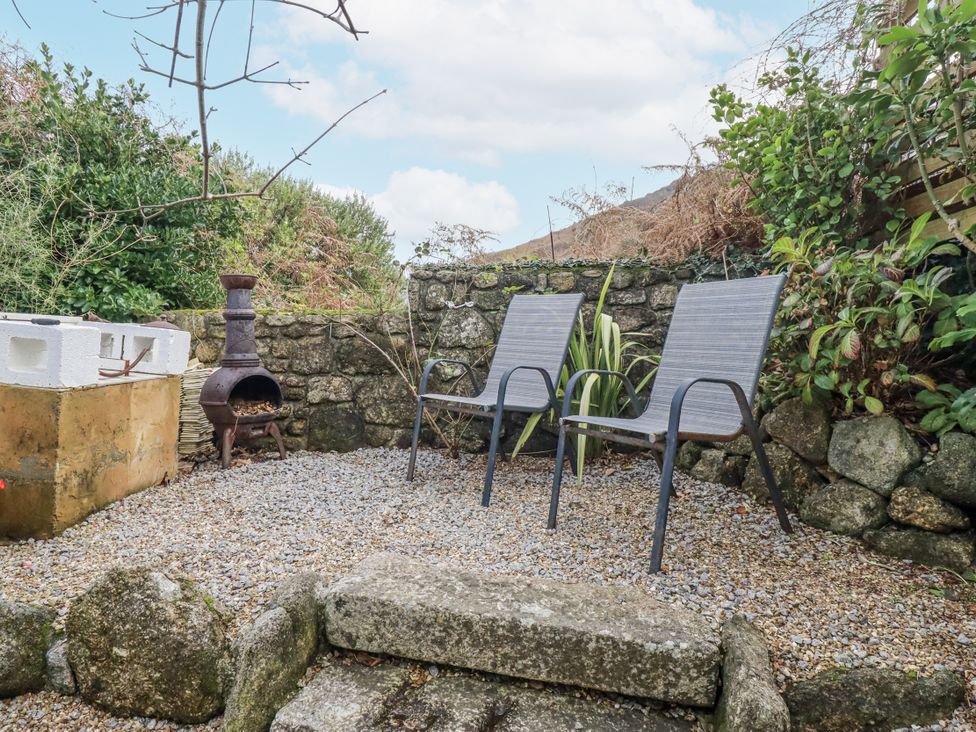 A garden with two chairs and a fire pit at Cove Retreat in Penzance