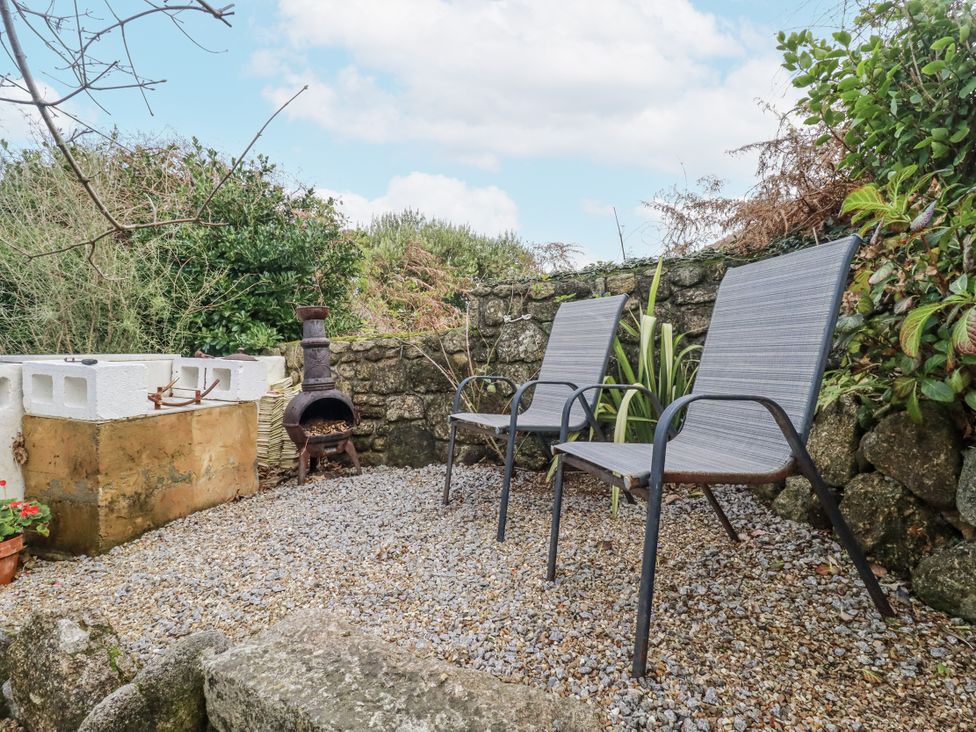 A garden with chairs and a chimenea at Cove Retreat in Penzance