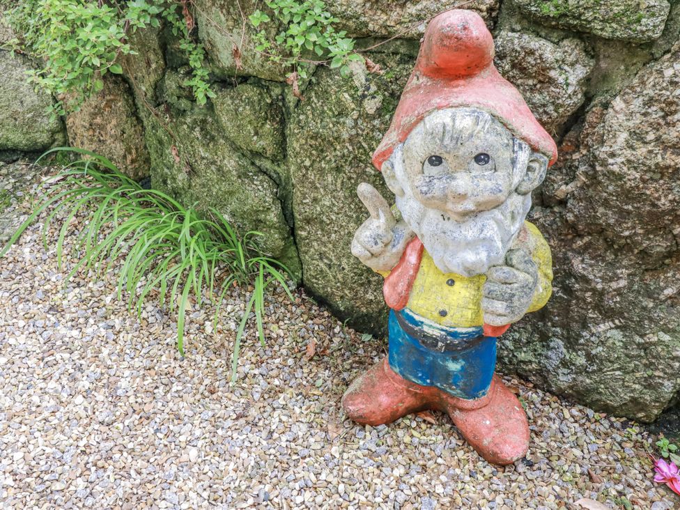 A gnome statue in a gravel garden area at Cove Retreat in Penzance