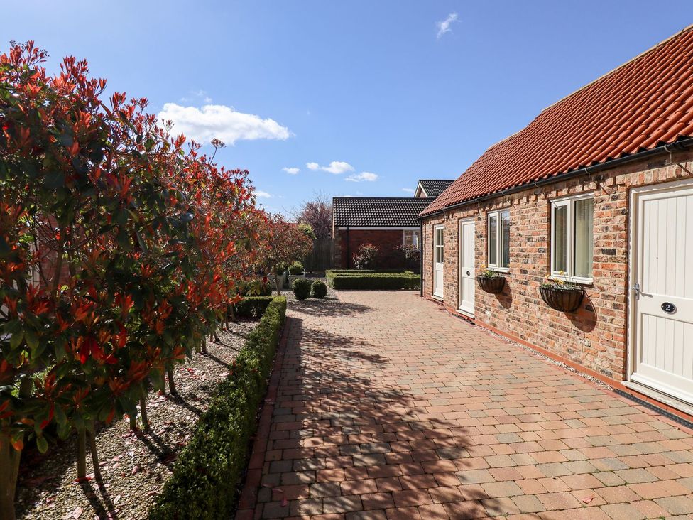 An outdoor area with brick buildings and plants at The Granary in Louth