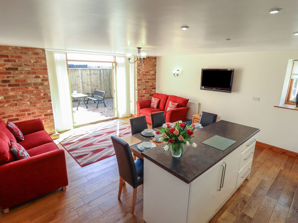 A living room with a kitchen island and seating area at The Granary in Louth