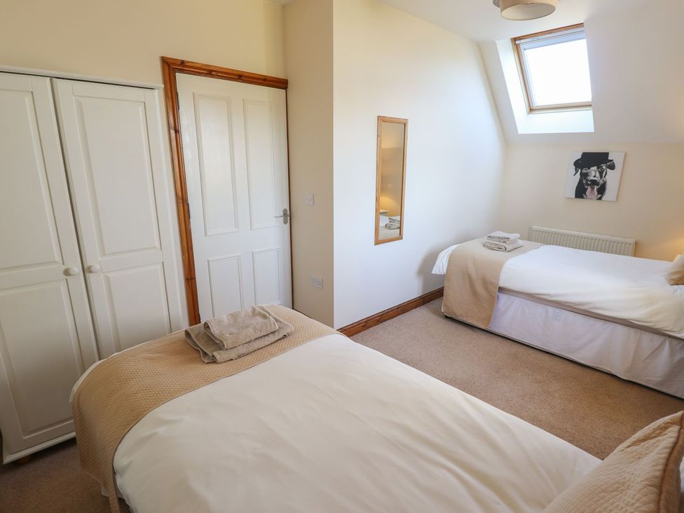 A bedroom with two beds and a wardrobe at The Granary in Louth