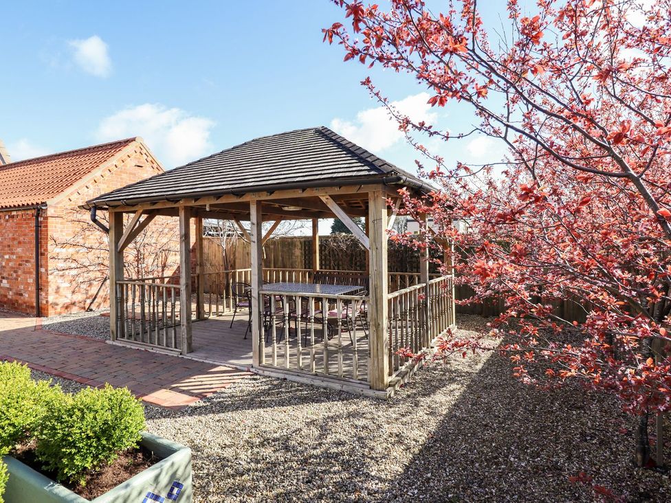A gazebo with a table and chairs in a garden at The Granary in Louth