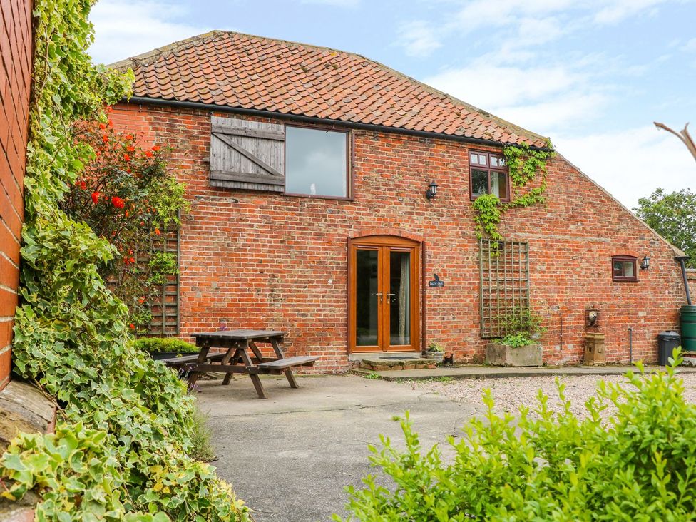 An outdoor view of a brick building with a table and chairs at Barn Owl in Louth