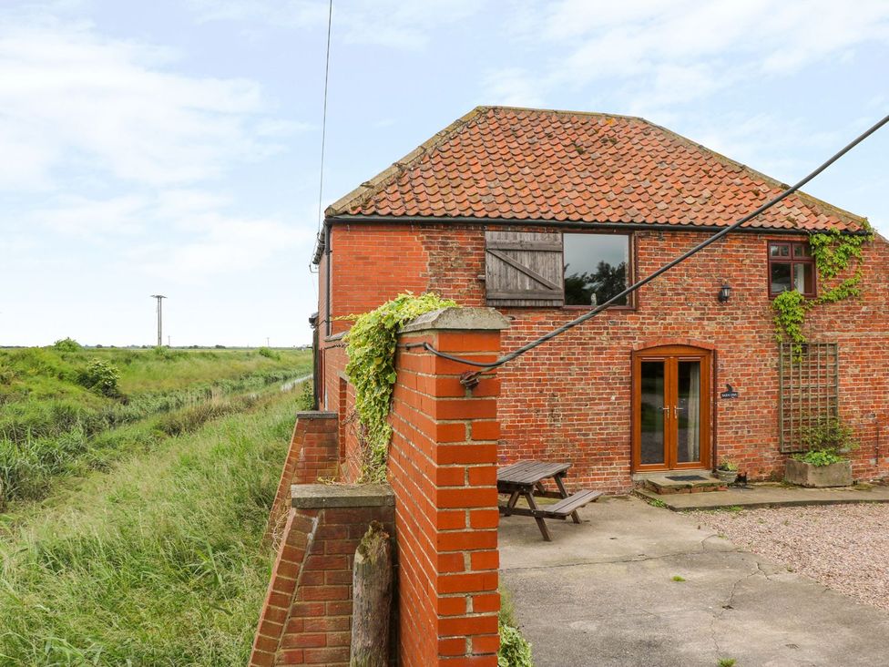 An outdoor view of a brick house with a table and chairs at Barn Owl in Louth