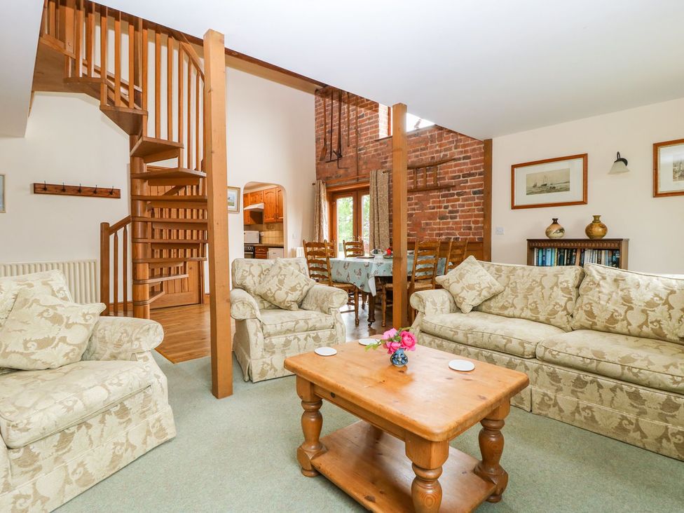 A living room with a staircase and a dining area at Barn Owl in Louth