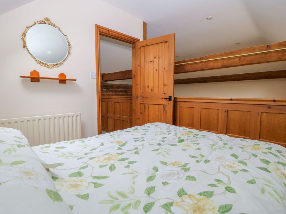 A bedroom with a bed and a mirror at Barn Owl in Louth