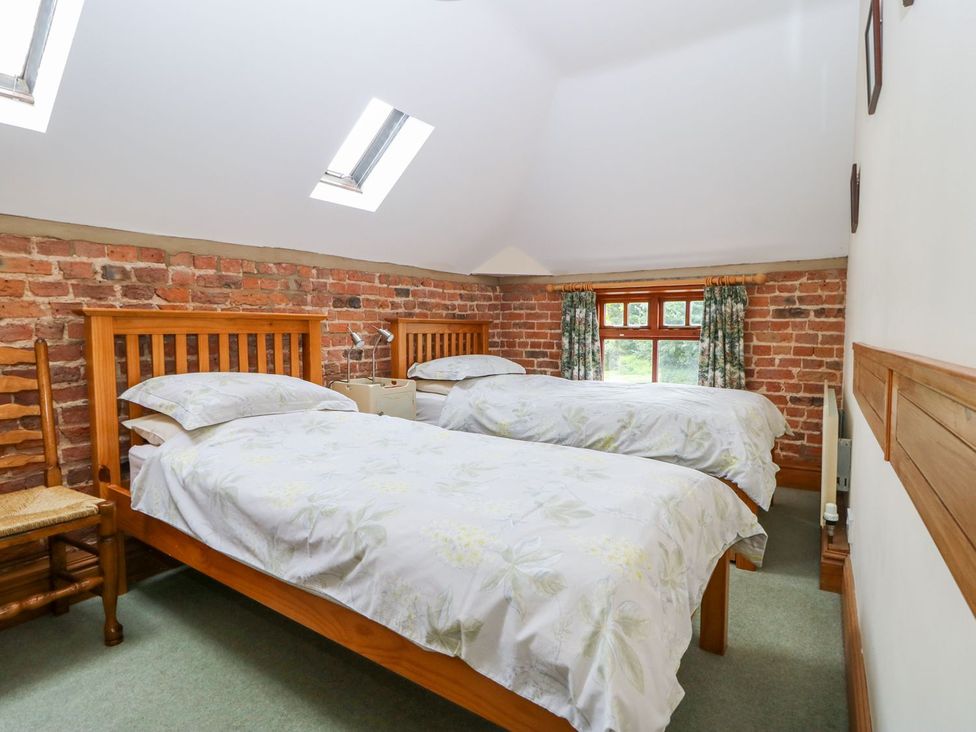A bedroom with two beds and a window at Barn Owl in Louth