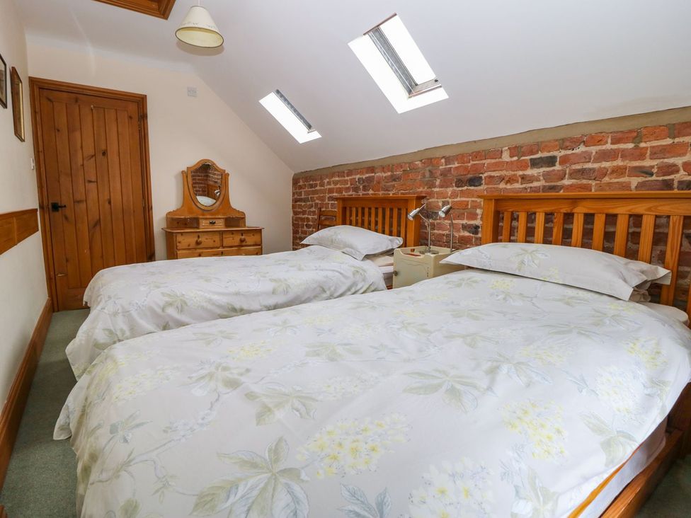 A bedroom with two beds and a dresser at Barn Owl in Louth