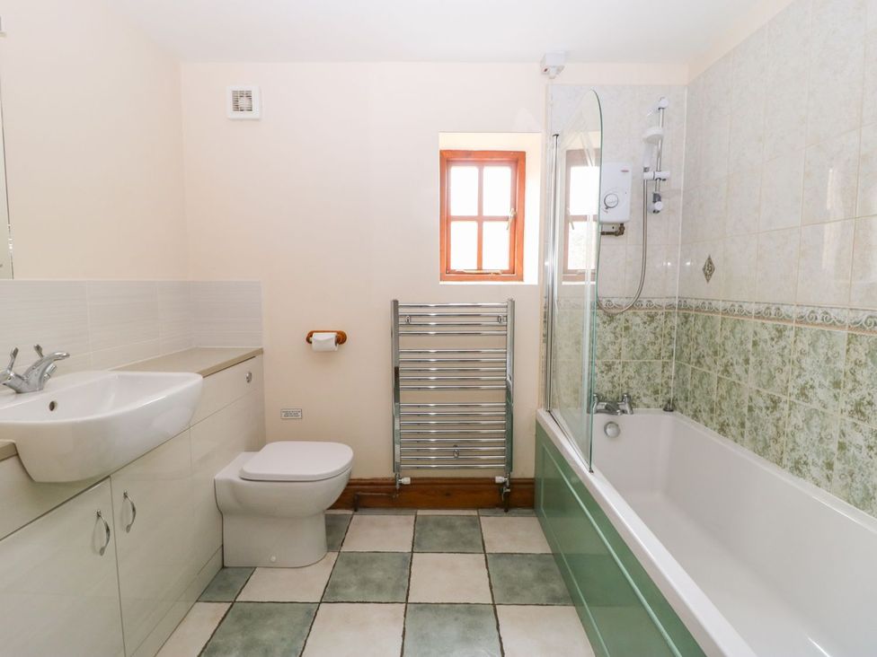 A bathroom with a sink, toilet, and bathtub at Barn Owl in Louth