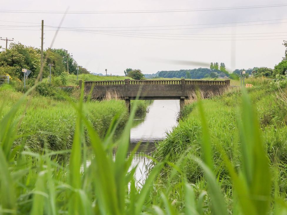 A view of a bridge over water with grass on the banks