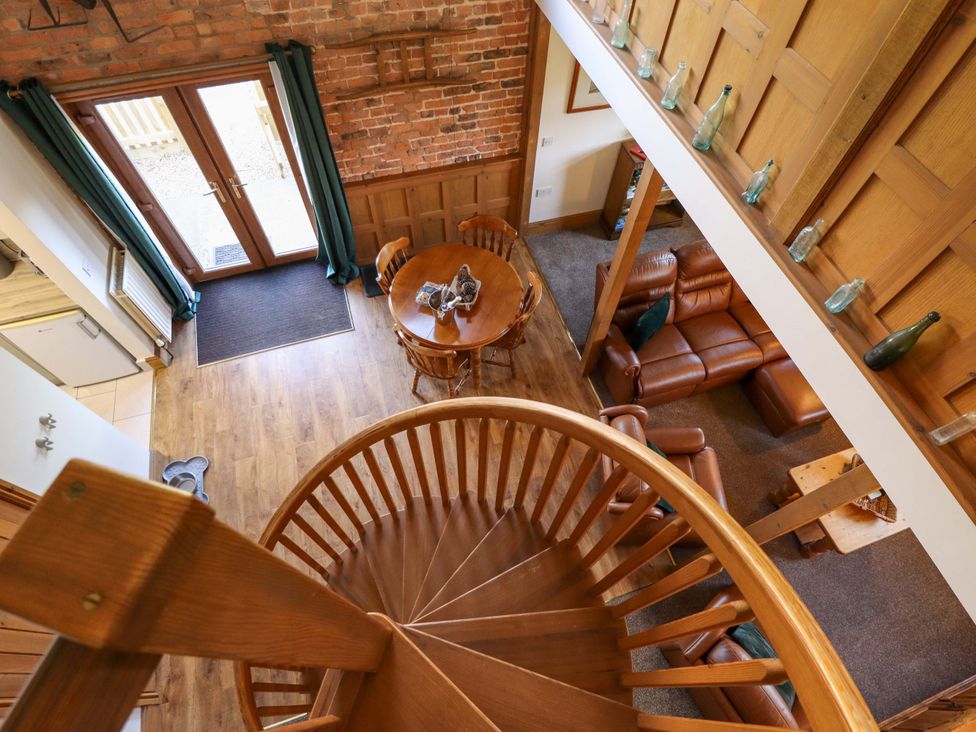 A living room with a staircase and sofa at Barn Owl near Louth