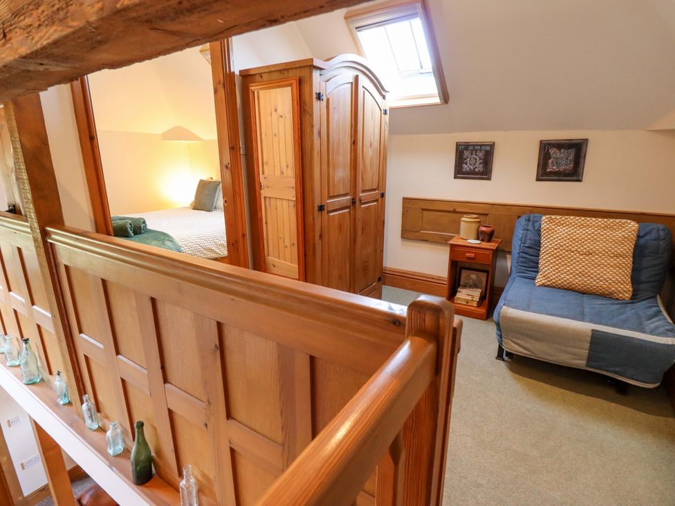 A bedroom with a bed and armchair at Barn Owl near Louth