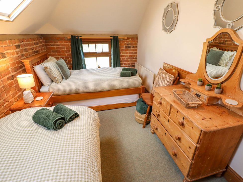 A bedroom with two beds and a dressing table at Barn Owl near Louth