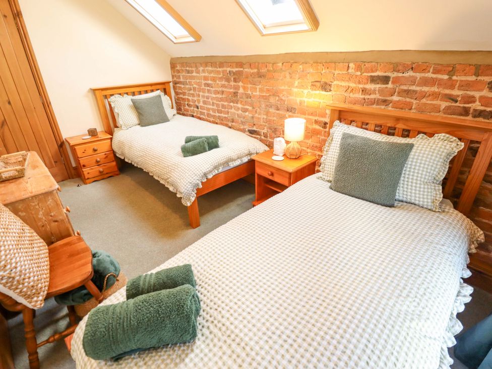 A bedroom with two beds and a nightstand at Barn Owl near Louth