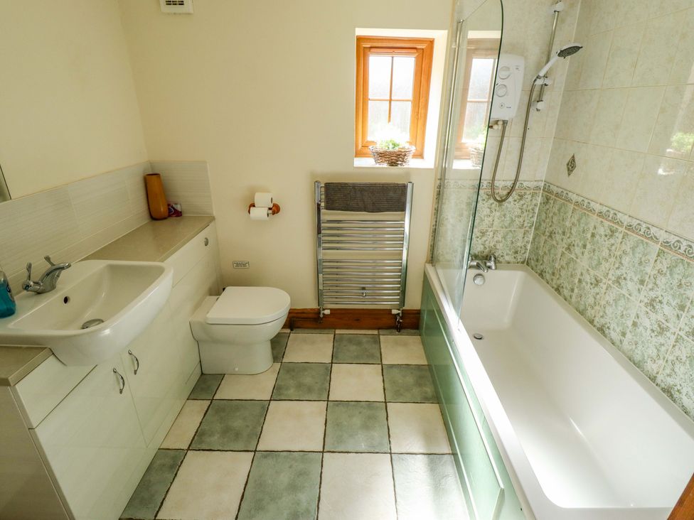 A bathroom with a sink, toilet, and bathtub at Barn Owl near Louth