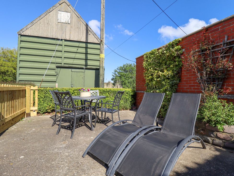 A garden with seating area and a green barn at Barn Owl near Louth