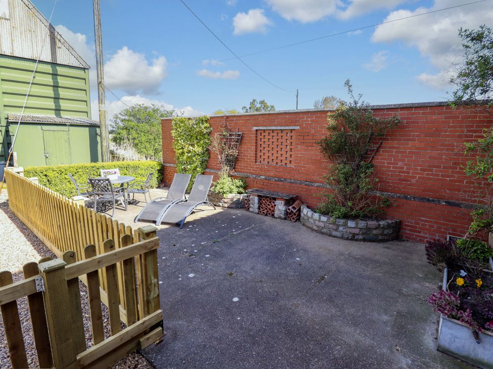 An outdoor area with chairs, loungers, and a table at Barn Owl near Louth