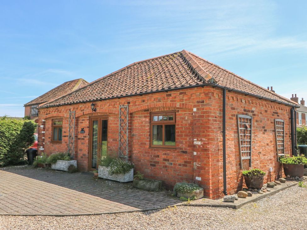 A brick house with windows and flower pots at Kingfisher in Louth