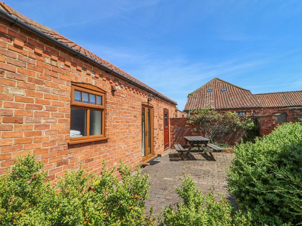 An outdoor area with brick walls and seating at Kingfisher in Louth