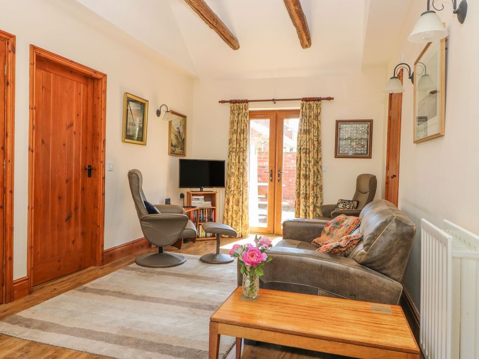 A living room with a sofa and TV at Kingfisher in Louth