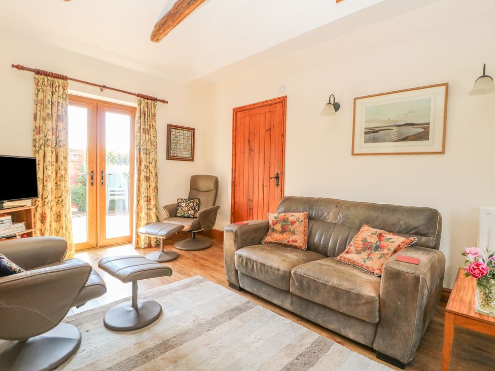 A living room with a sofa and armchairs at Kingfisher in Louth