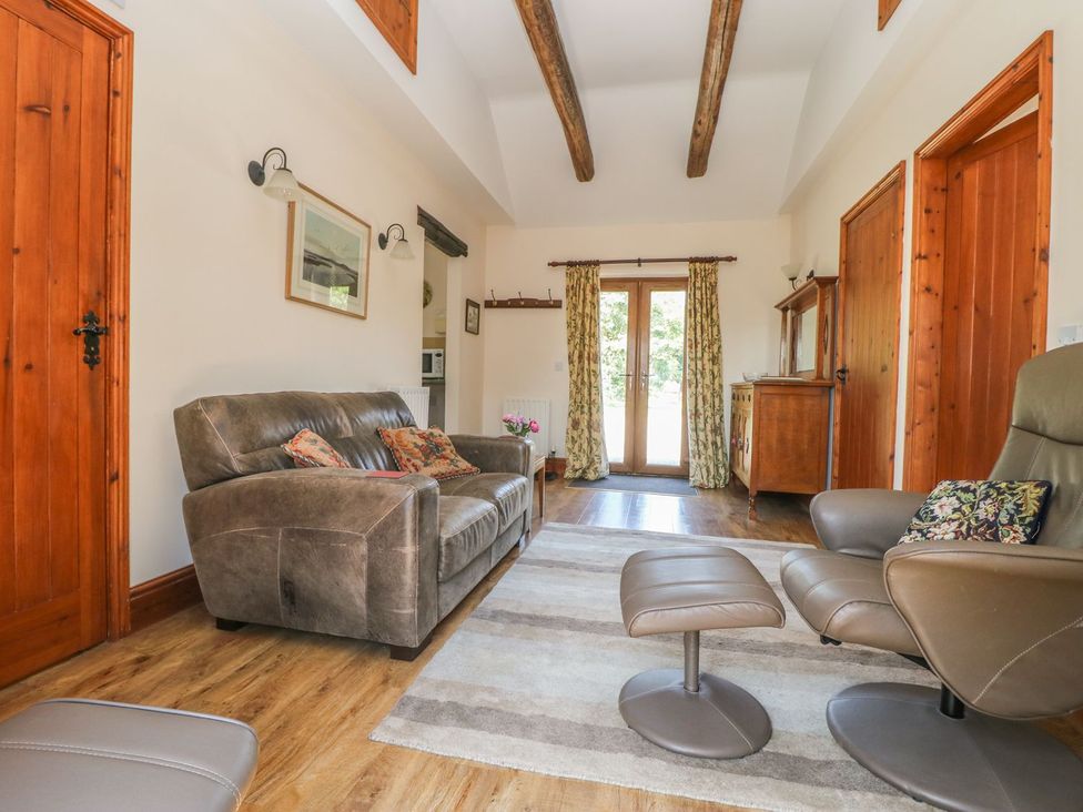 A living room with a sofa and armchair at Kingfisher in Louth