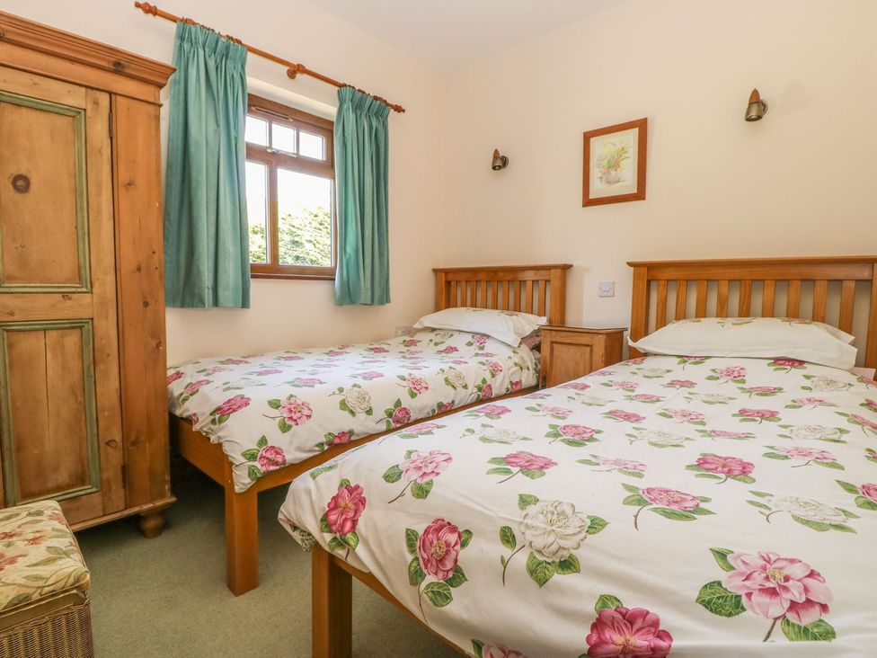 A bedroom with two beds and a wardrobe at Kingfisher in Louth