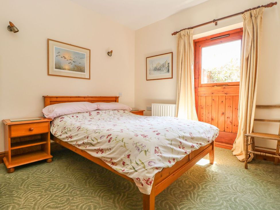 A bedroom with a bed and nightstand at Kingfisher in Louth