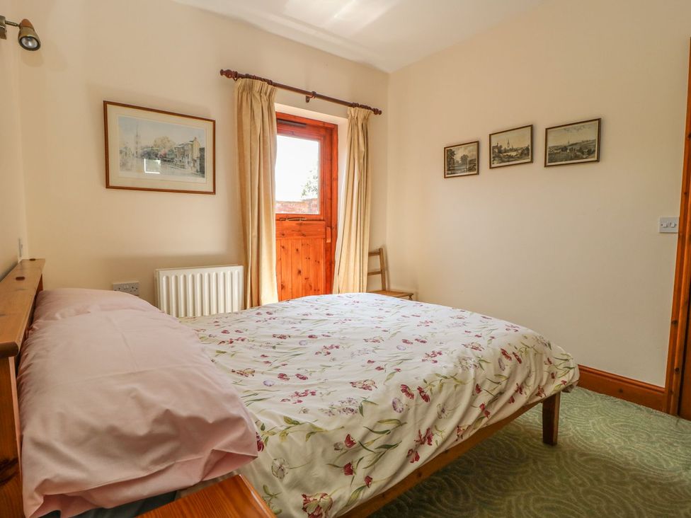 A bedroom with a bed and window at Kingfisher in Louth