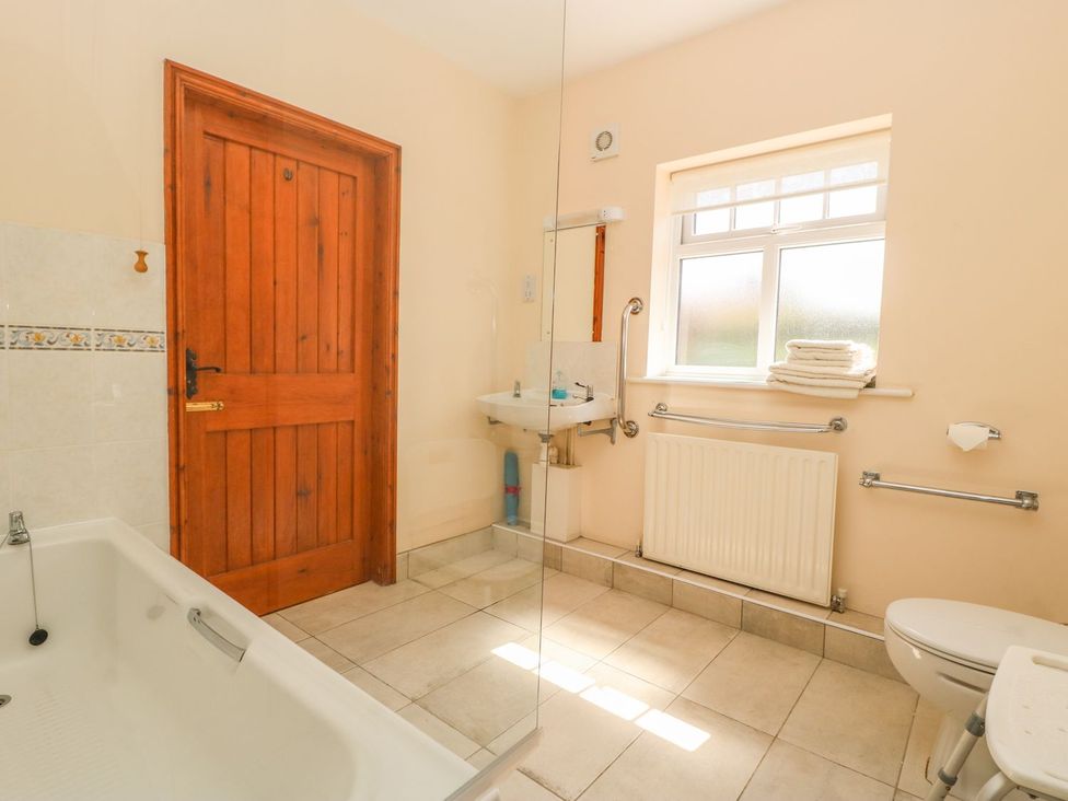 A bathroom with a bathtub, shower, toilet, and sink at Kingfisher in Louth