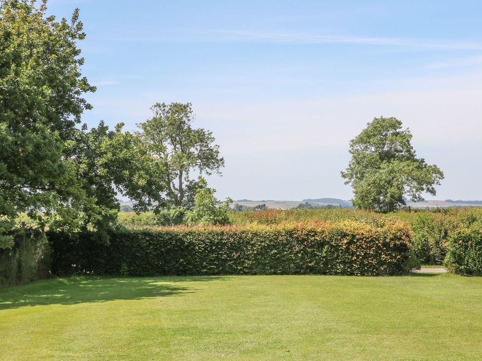 A garden with grass and trees at Kingfisher in Louth
