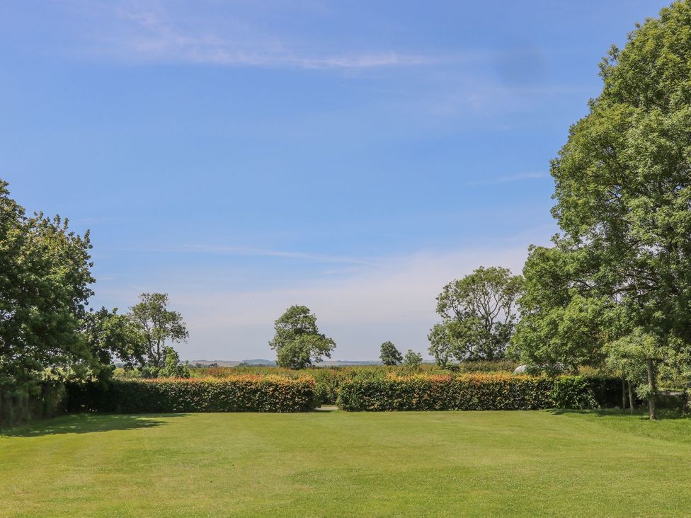 A garden with grass and trees at Kingfisher in Louth