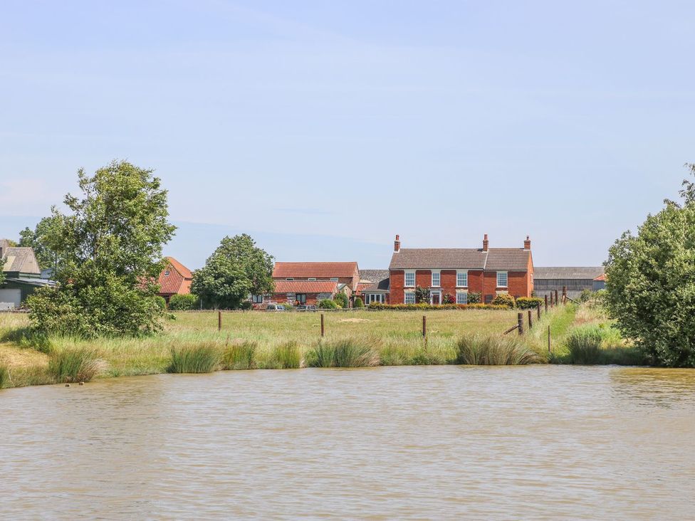 A view of houses and land across a body of water at Kingfisher in Louth