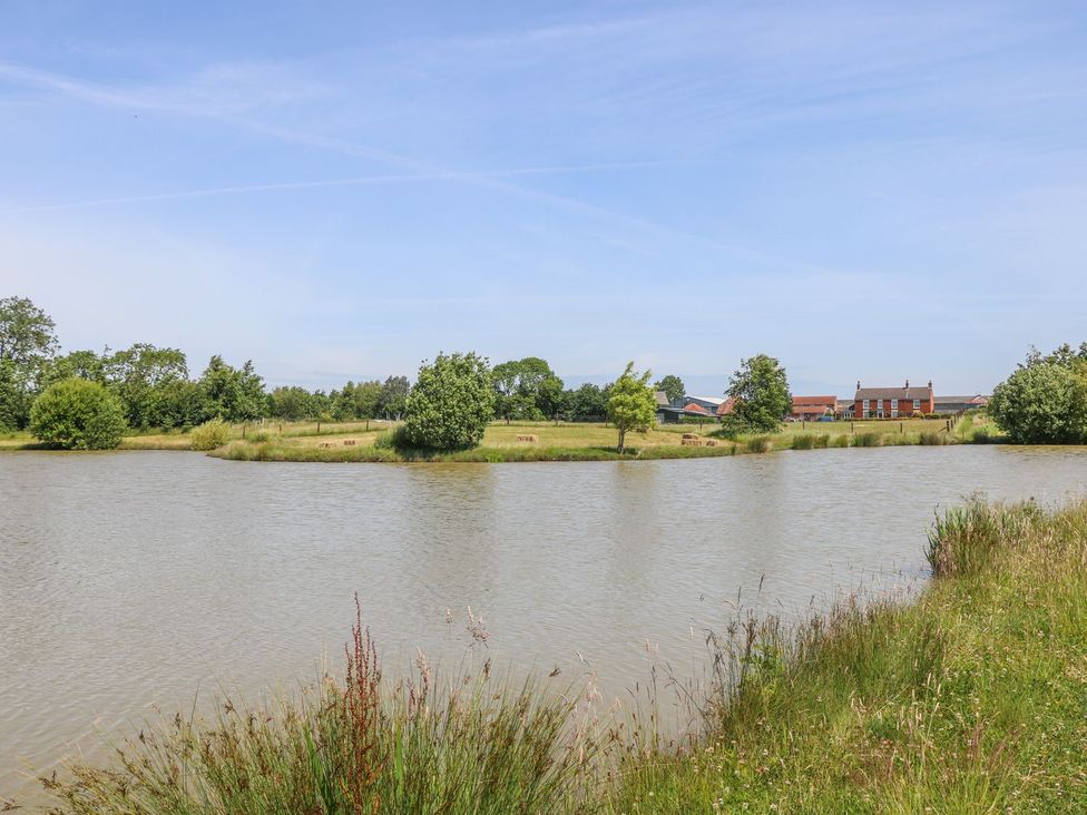A landscape with water and trees near buildings at Kingfisher in Louth