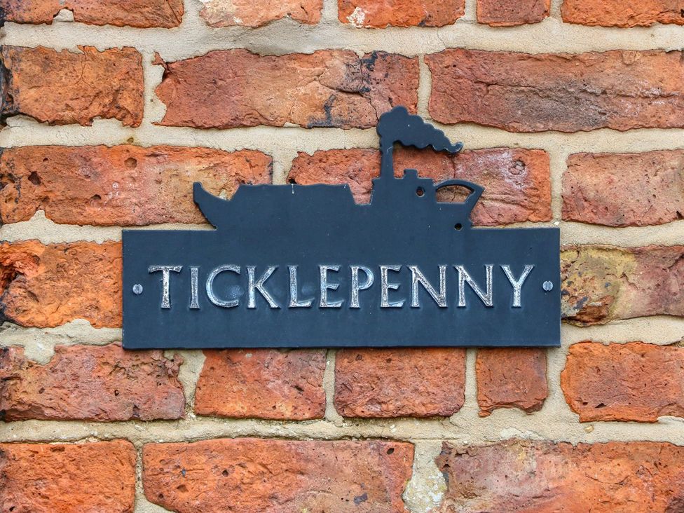 A name plaque with Ticklepenny on a brick wall at Ticklepenny Louth
