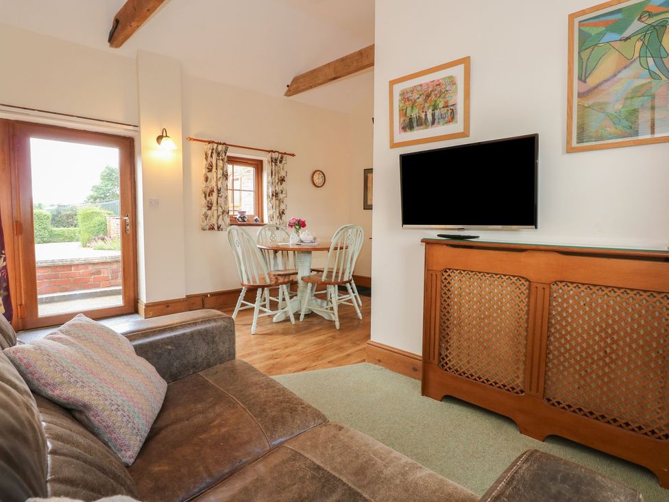A living room with a sofa and dining area at Ticklepenny in Louth