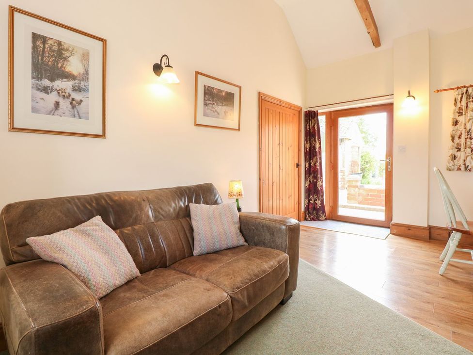 A living room with a sofa and door at Ticklepenny in Louth