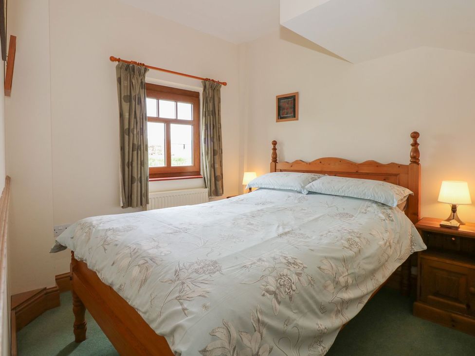 A bedroom with a bed and nightstands at Ticklepenny in Louth