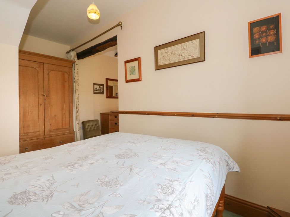 A bedroom with a bed, wardrobe, and chair at Ticklepenny in Louth