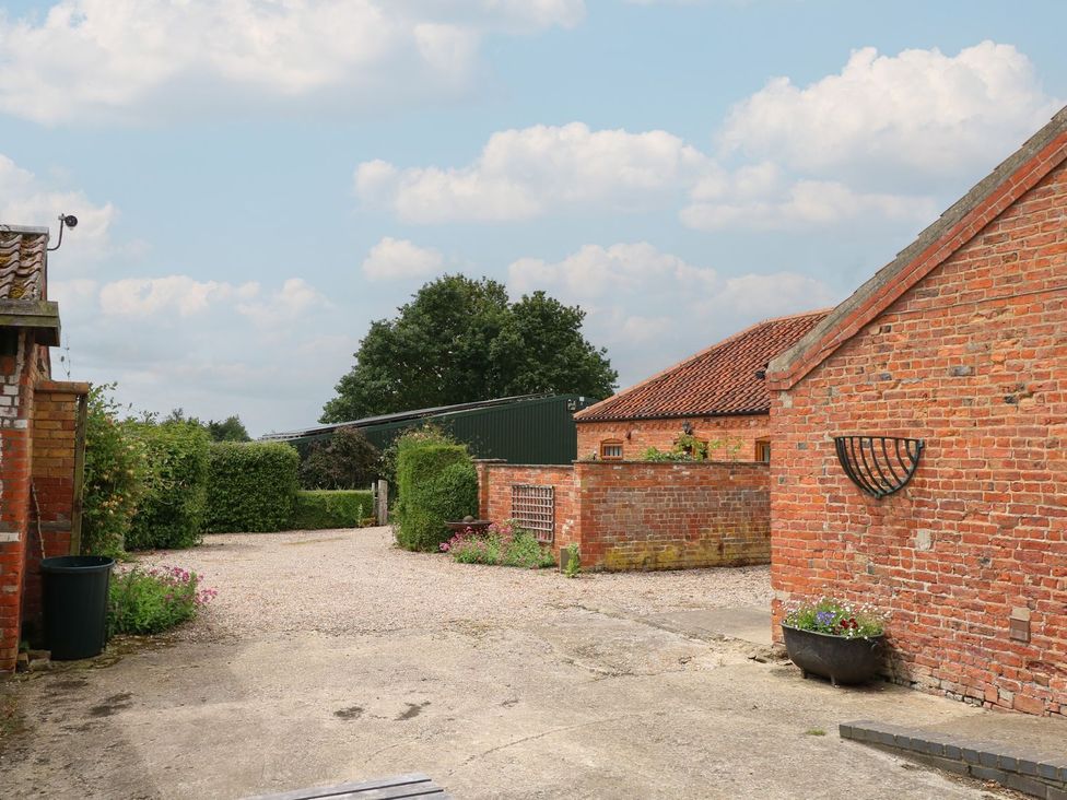 An outdoor area with brick buildings and a gravel driveway at Ticklepenny in Louth