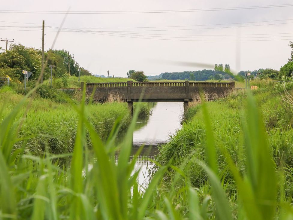 A bridge over a waterway with grass on either side at Ticklepenny in Louth
