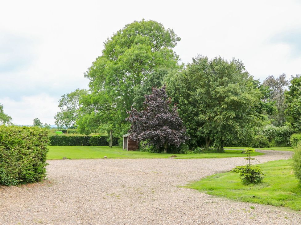 An outdoor area with a gravel driveway and trees at Ticklepenny, Louth