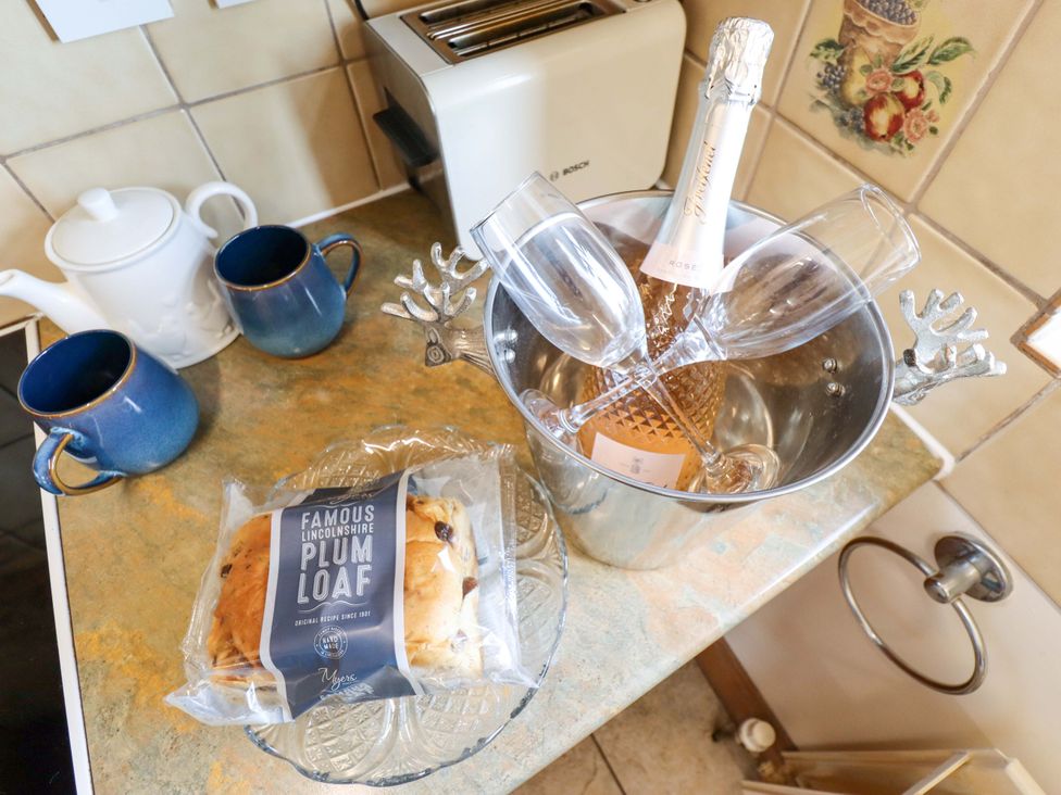 A kitchen with a toasting machine and champagne bottle at Ticklepenny in Louth