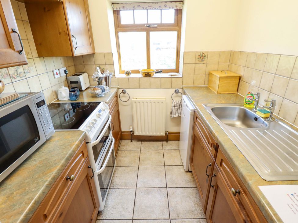 A kitchen with appliances and a window at Ticklepenny in Louth
