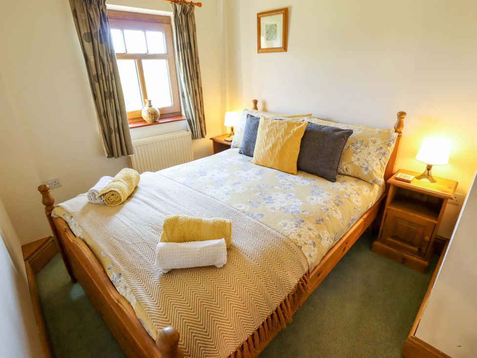 A bedroom with a bed and bedside tables at Ticklepenny in Louth